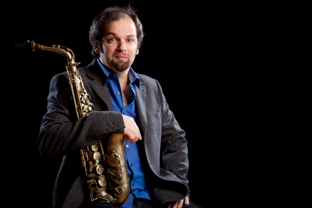 Jesse in the sunny garden with the saxophone on the garden table.