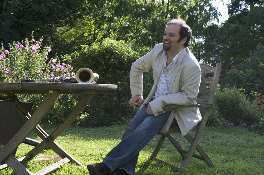 Jesse in the sunny garden with the saxophone on the garden table.